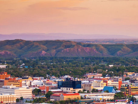 Aerial view of downtown Billings Montana at sunset with orange sky Rimrock sandstone cliffs and city skyline