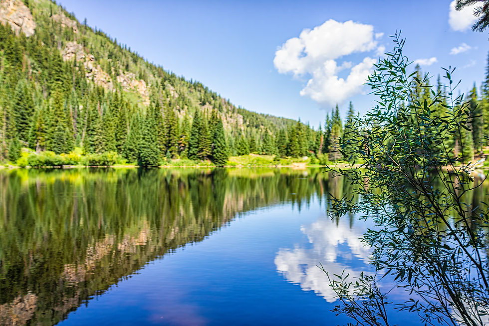 Crystal clear mountain lake reflection surrounded by pine forests in Beaver Creek Colorado — luxury family vacation in the Colorado Rockies