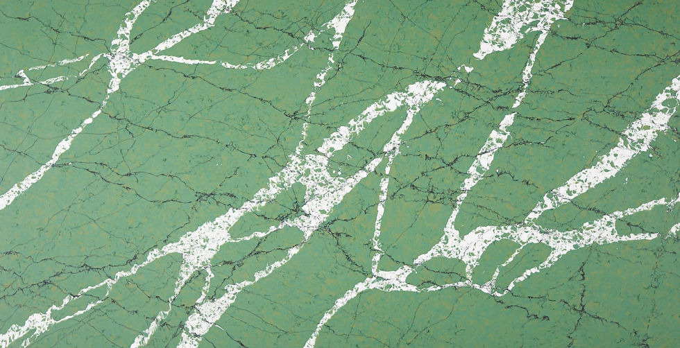 Green marble surface with white veining, creating an intricate pattern of Kalinga Stone. The organic lines evoke a natural, serene atmosphere.