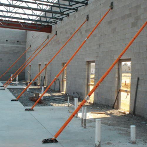 Thumbnail: Orange wall braces supporting a building under construction, with visible windows and doors.