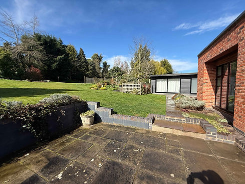 Patio and lawn area outside a red brick building.