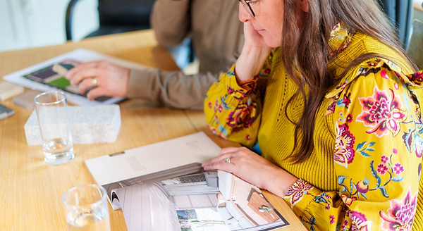 Woman in yellow blouse reviewing garden design plans