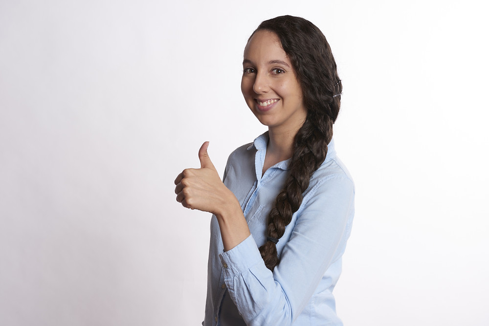 Smiling woman giving a thumbs up for good customer service