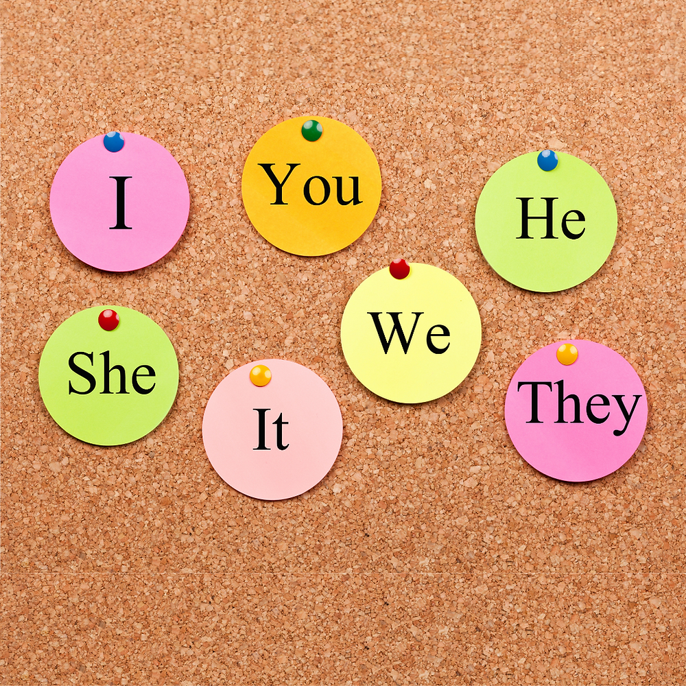 A bulletin board displays pronouns