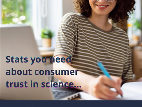 Woman holding a pen sitting in front of a computer.