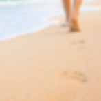 Bare feet walking on the beach
