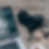 Camera on a table next to an open lap top computer.
