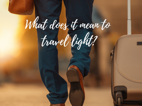 Traveler walking with a suitcase on wheels and a shoulder bag.