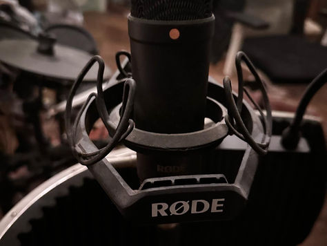 Close-up of a RØDE studio condenser microphone with a shock mount.
