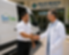 Professional handshake at medical center entrance.png