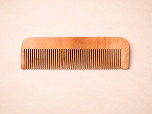 Natural neem wood comb placed on a wooden surface showcasing eco friendly hair grooming tool.
