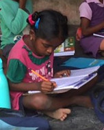 Small child taking notes in class.