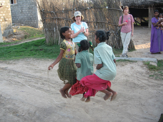 Three young girls jump rope at the same time
