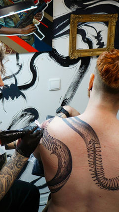 Tattoo artist creating a detailed design on a client’s skin
