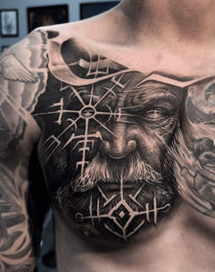 Norse mythology tattoo featuring symbolic runes, gods, and amulets
