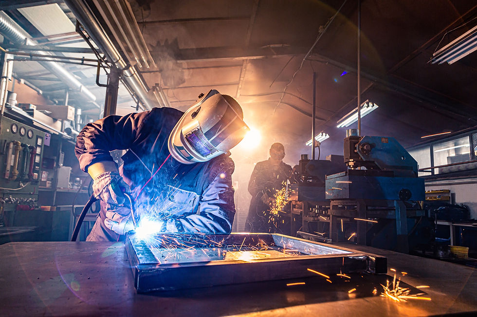 The two handymen performing welding and grinding at their workplace in the workshop, while