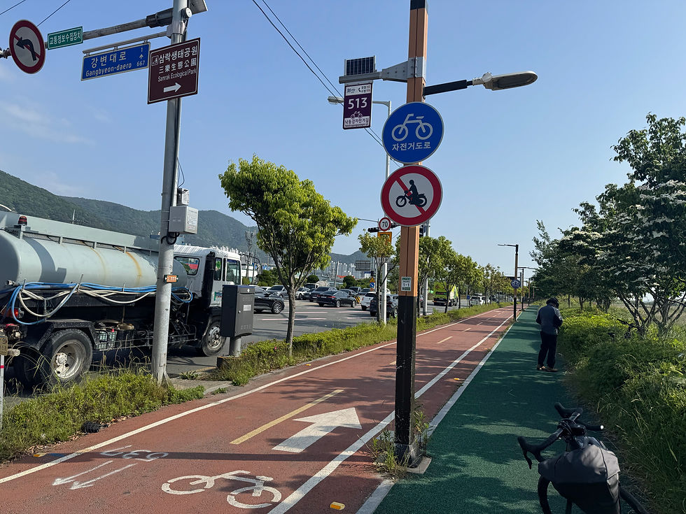 Cyclist path along Gangbyeon-daero under a clear blue sky.