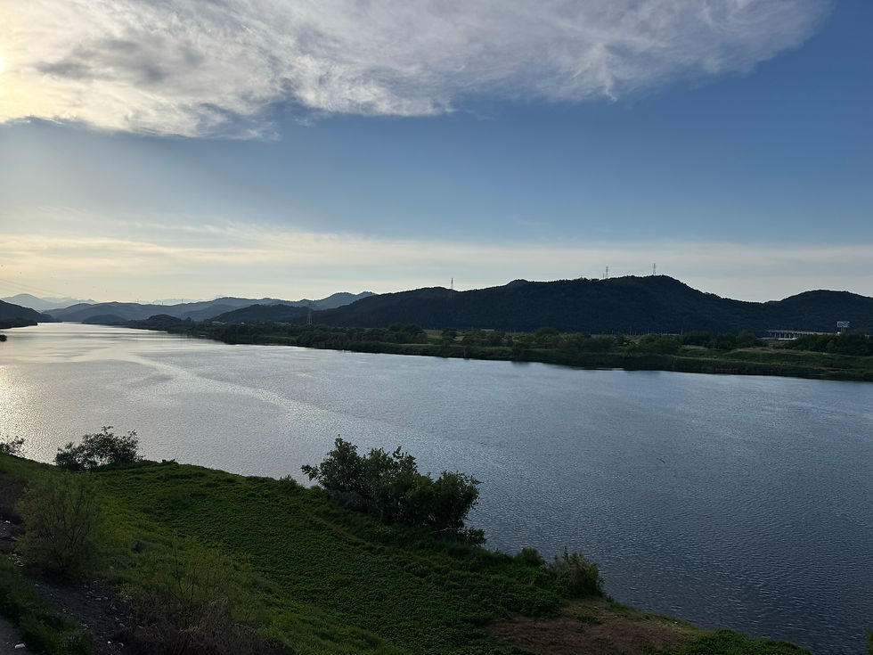 Serene river flowing beneath a cloud-streaked sky.