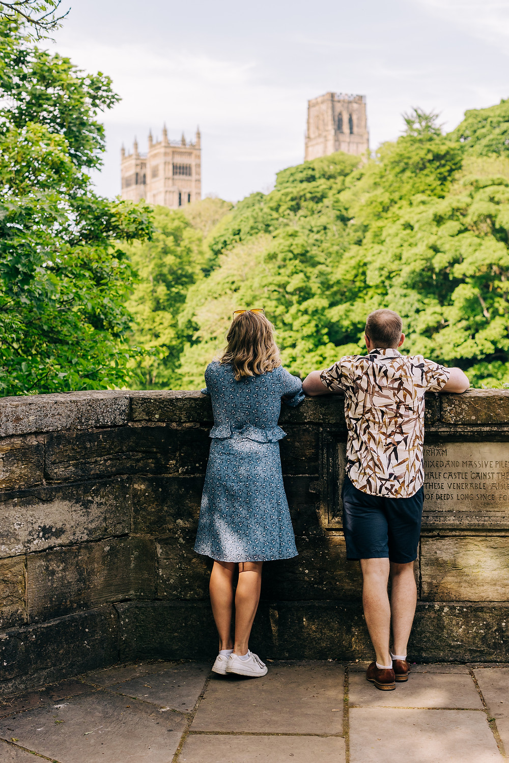 Couple looking at Durham cathedral romantic casual engagement shoot in the city