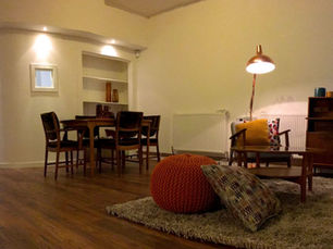 Interior shot of a tenant support hub with table and chairs, cushions and mood lighting
