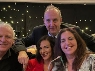 Barry, Joey, Andrew and Susan smiling with their award