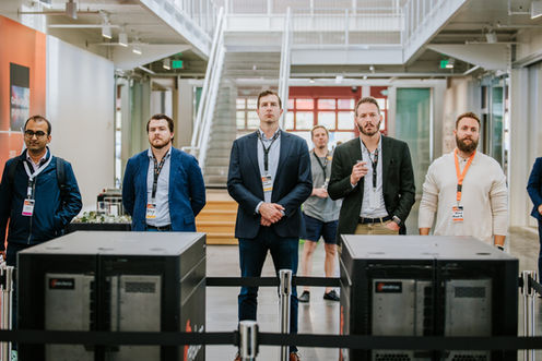 Five people standing in a modern office environment.