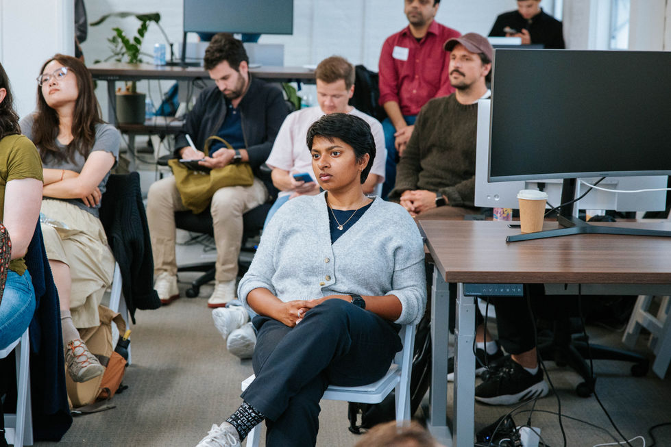 People seated in a meeting or workshop setting.