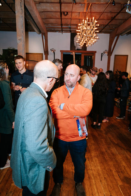 Group of tech professionals networking and speaking during a startup and AI conference event in the San Francisco Bay Area.