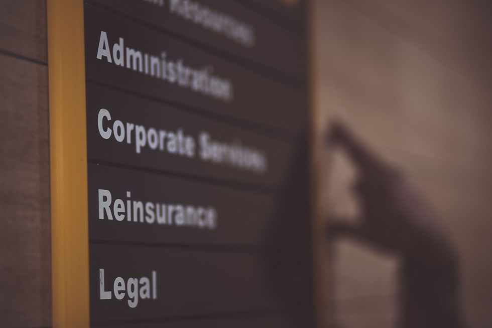 Corporate office directory sign listing legal and administrative departments, representing LLC business entity structure.
