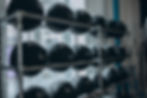 Fitnessstudio: Schwarze Medizinbälle im Regal