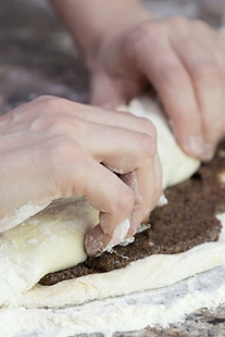 a-woman-wraps-a-dough-in-the-form-of-a-r