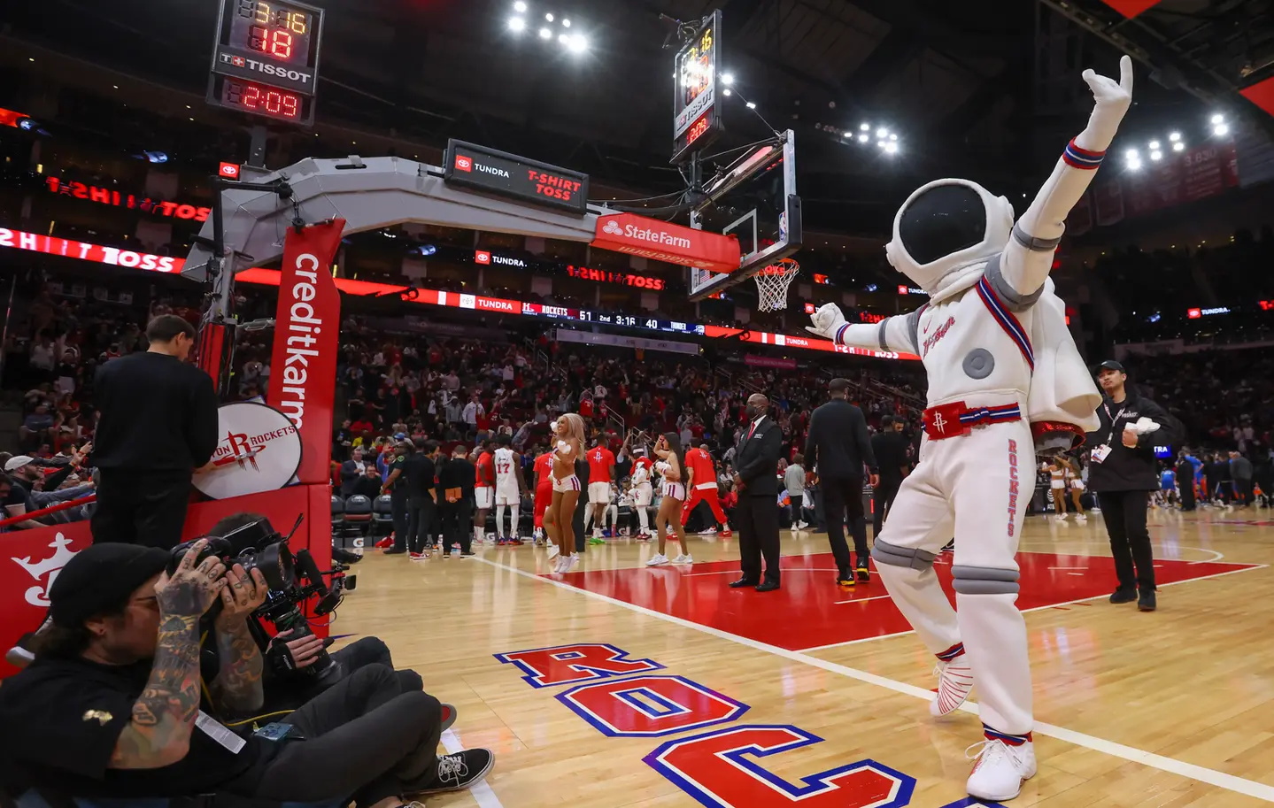 Astronaut mascot performing at a basketball game.