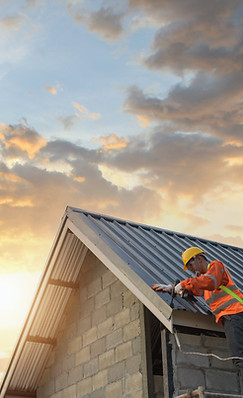 Worker installs and secures metal roofing to a structure