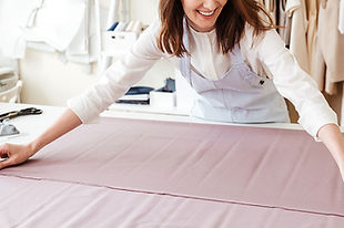 woman-seamstress-spreading-fabrics-workshop-(1).jpg
