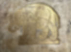 A close up detail of a gold elephant on a clearly historic document.