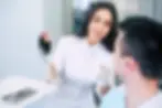 Spanish-speaking dentist in Washington, DC, holding a mirror to show the patient the results of her work.