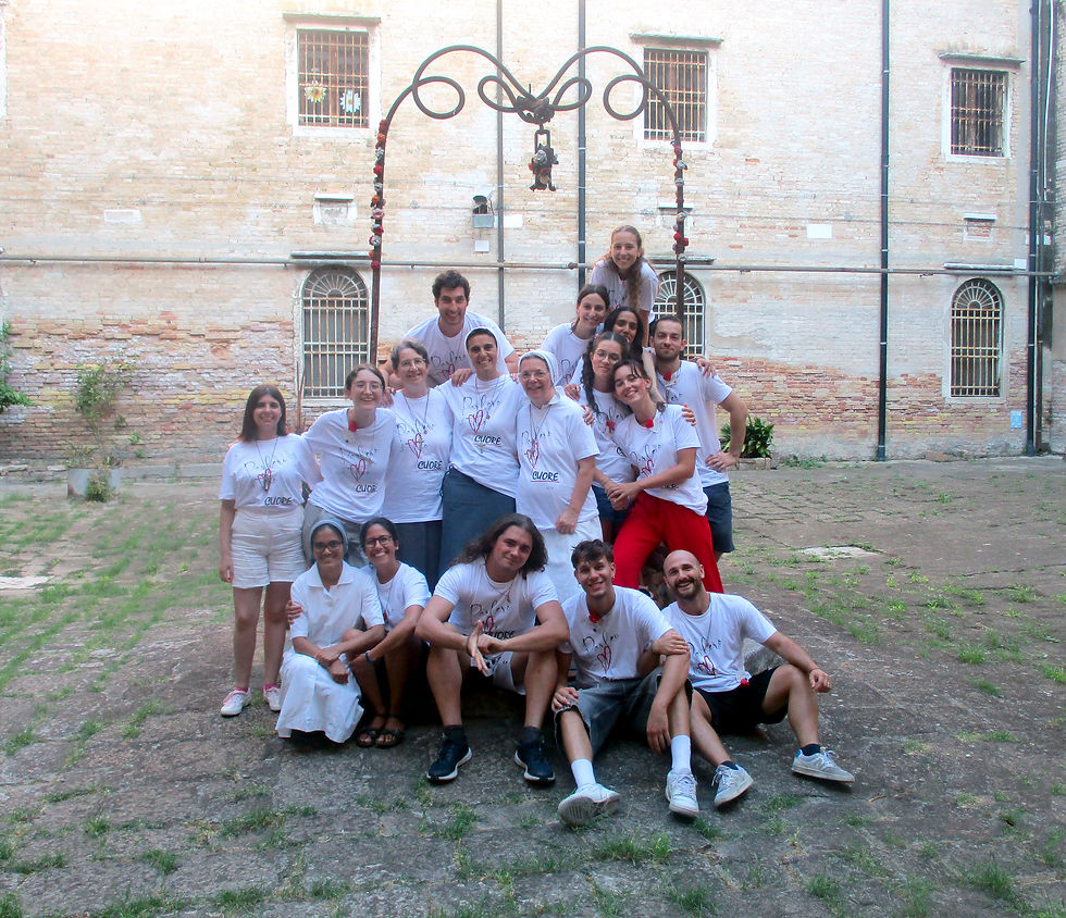 gruppo di giovani con suore al pozzo del cortile del carcere con magliette con scritto'cercami il cuore'