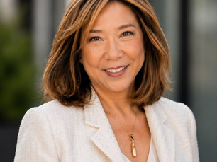 Julie Tung, Senior Advisor at Personar, smiling in a cream blazer against a soft-focus outdoor background.