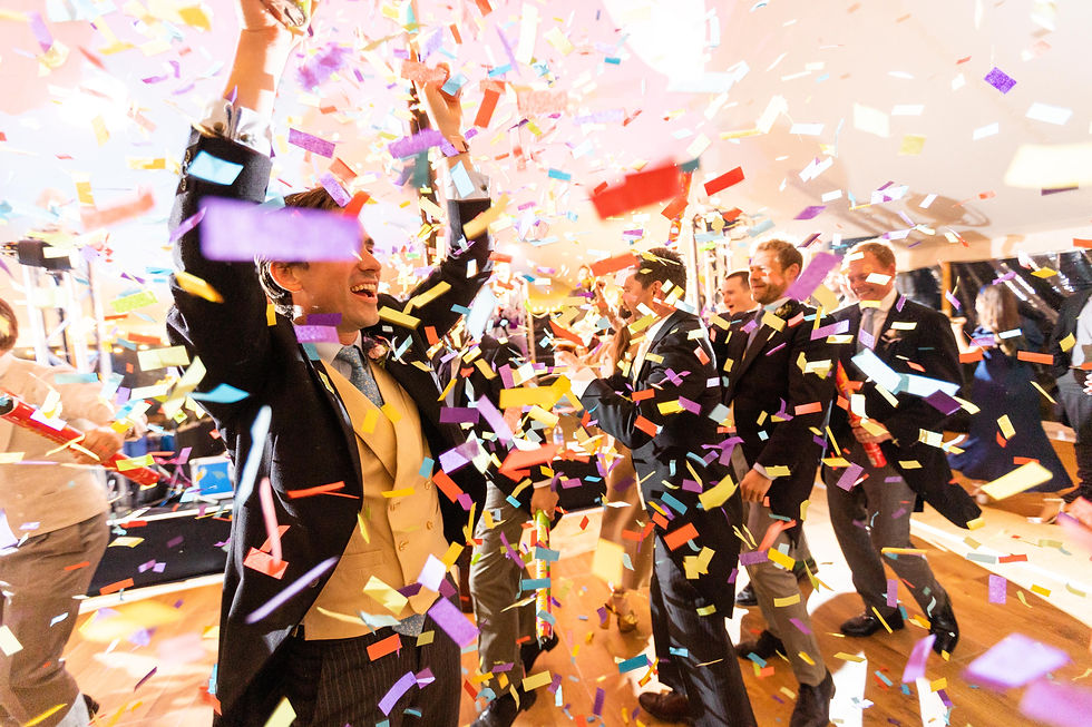 Inside a Peacock and Bow pole and canvas marquee the groomsmen are showered with biodegradable confetti from a confetti canon on the Auckland Oak dance floor.