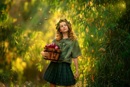 נערה אוחזת דלי מעץ עם תפוחים