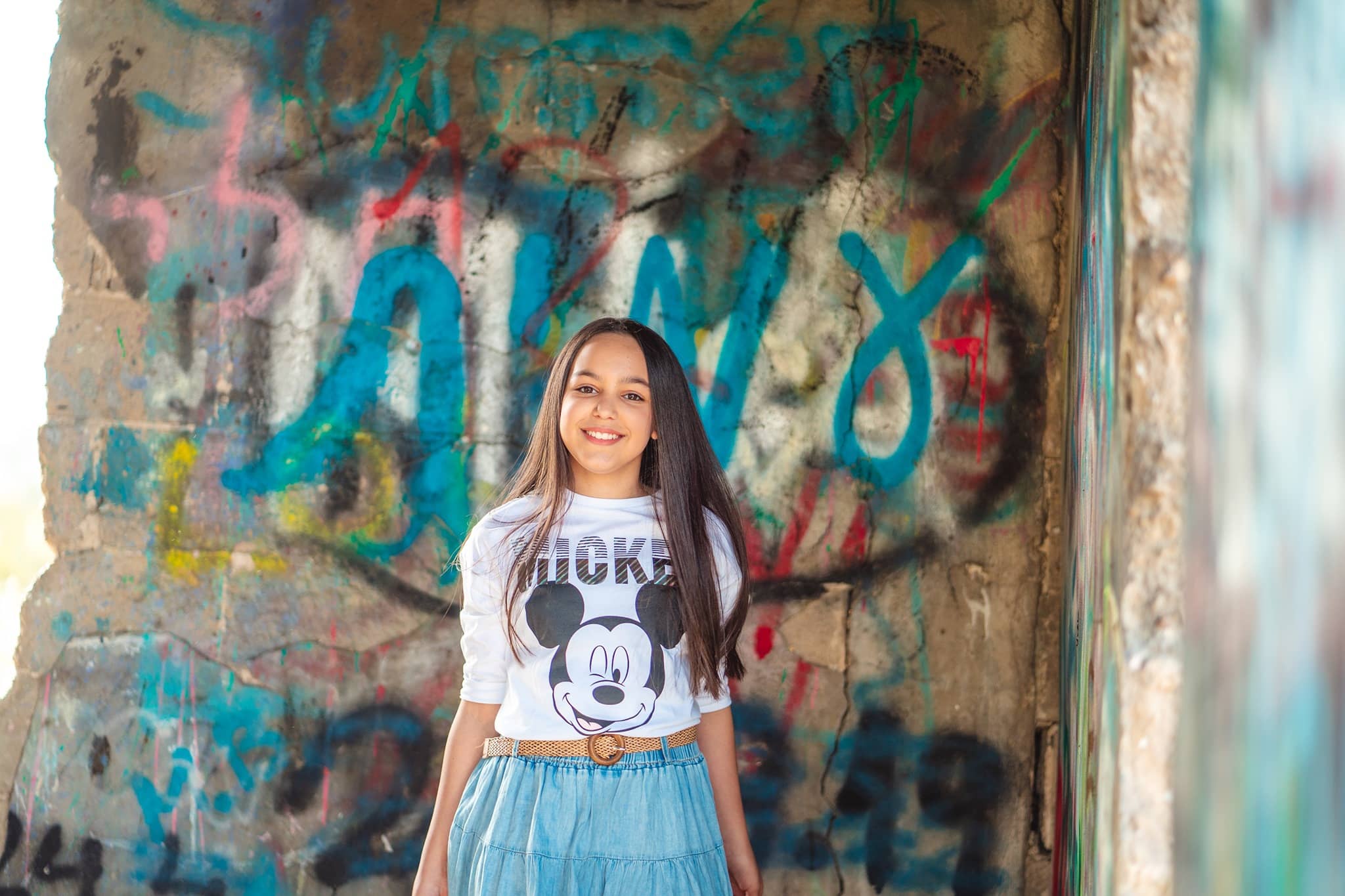 דוגמה לתמונה מבוק בת מצווה. להגדלה לחצו עליה. נערה עומדת על רקע קיר גרפיטי