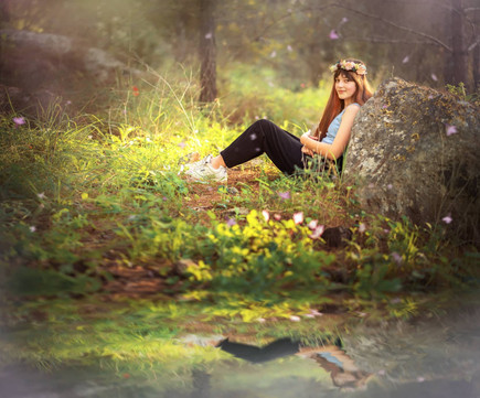 נערה יושבת עם השתקפות שלה בנחל