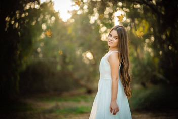 נערה מחייכת למצלמה עם עלים נושרים מסביבה. דוגמה לבוק בת מצווה