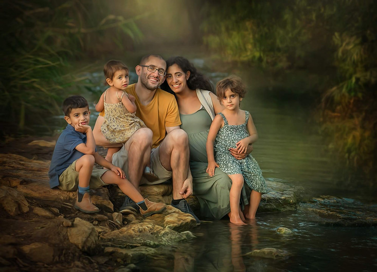 דוגמה לצילומי הריון ומשפחה. משפחה יושבת בנחל ומחייכת למצלמה. להגדלת התמונה תלחצו עליה