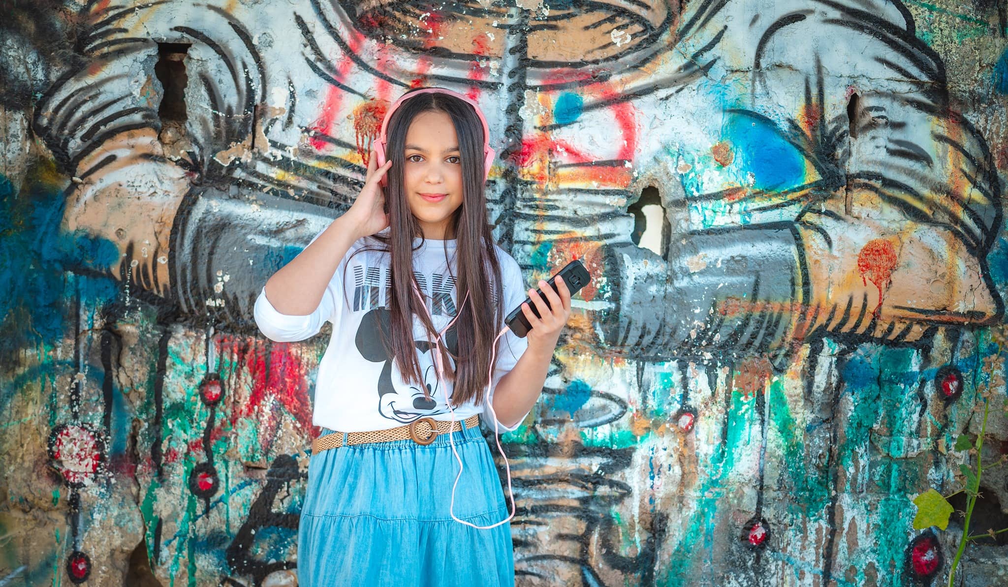 דוגמה לתמונה מבוק בת מצווה. להגדלה לחצו עליה. נערה עומדת על רקע קיר גרפיטי