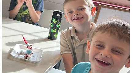 2 young microschool students laughing in class.