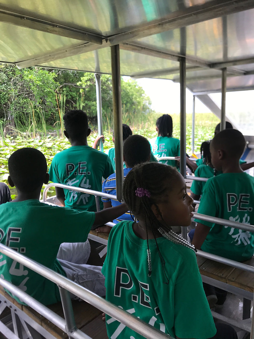Students in green shirts riding a covered boat