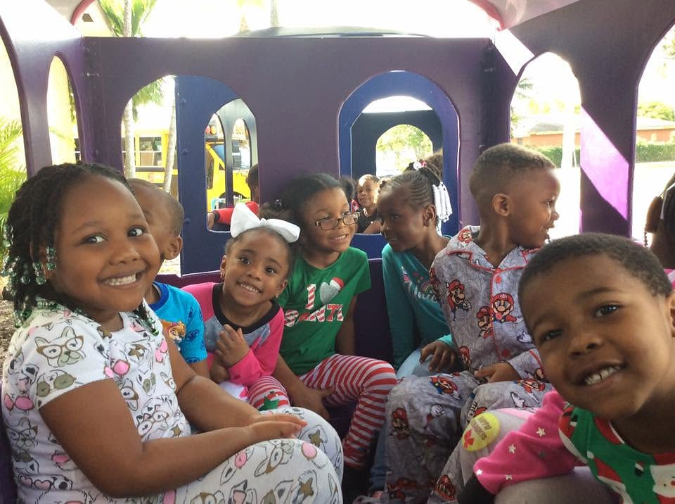 Smiling children in pajamas enjoying student life on a train.