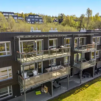 Dronefoto av fasaden og verandaen til et leilighetsbygg i Lillehammer.