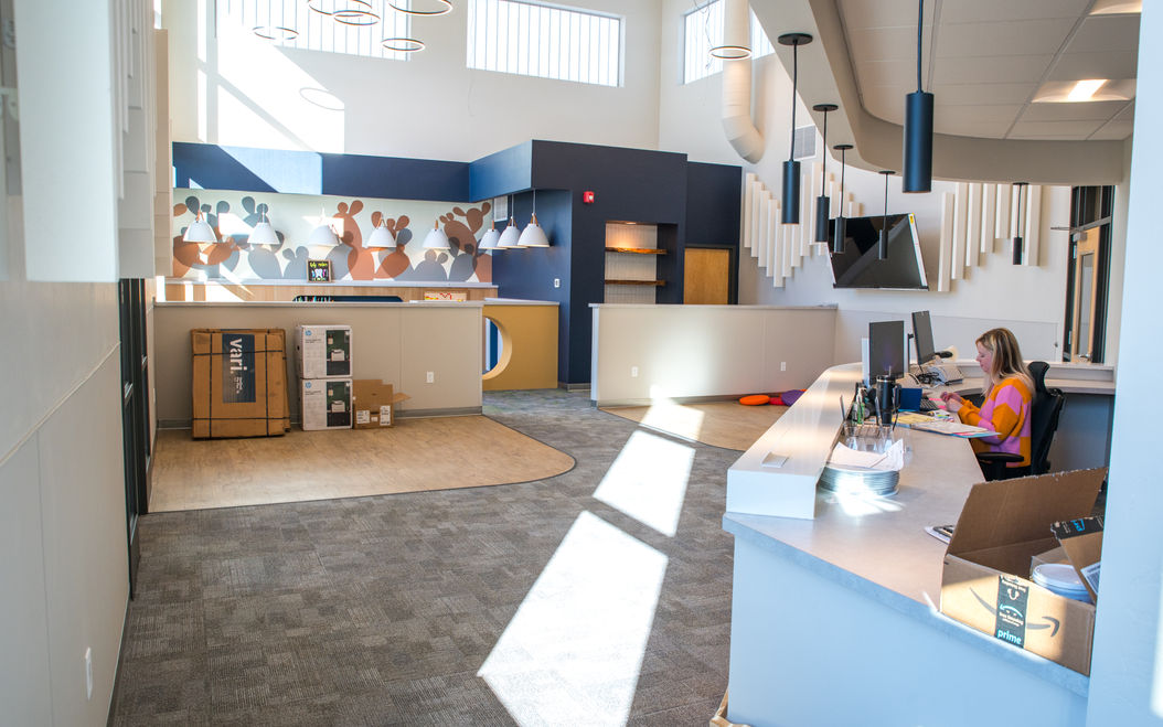 waiting area in children's dentist office with woman at front desk
